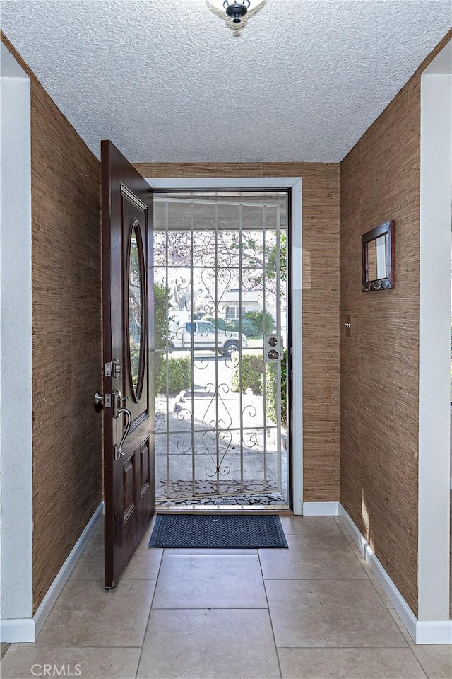 entryway with baseboards and a textured ceiling