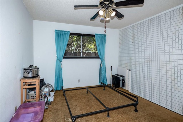 interior space featuring a ceiling fan, carpet flooring, and a textured ceiling