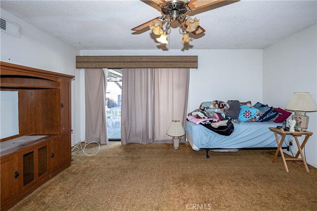 carpeted bedroom with visible vents, ceiling fan, and a textured ceiling