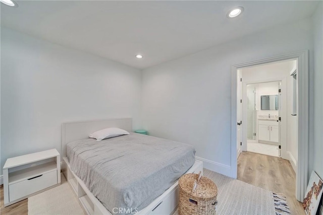 bedroom with light wood-style floors, recessed lighting, a sink, and baseboards