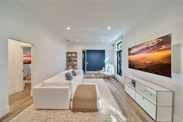 living room featuring light wood-style floors, baseboards, ornamental molding, and recessed lighting