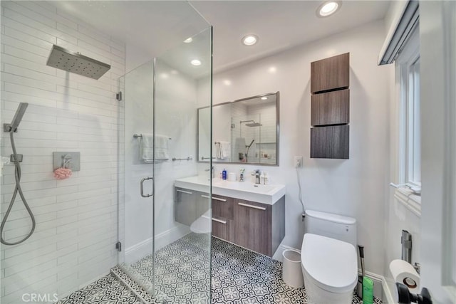 bathroom featuring a stall shower, baseboards, toilet, vanity, and recessed lighting