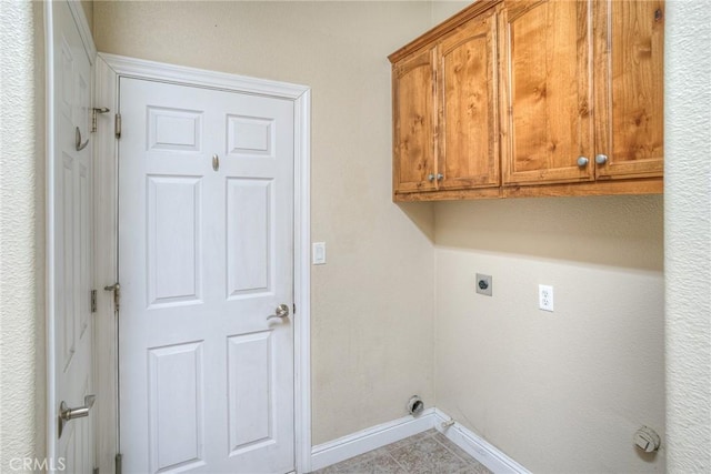 laundry room with cabinet space, tile patterned flooring, baseboards, and electric dryer hookup