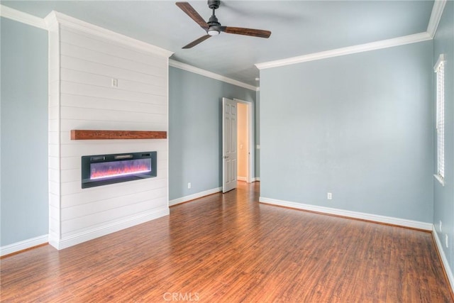 unfurnished living room with a large fireplace, ceiling fan, baseboards, and wood finished floors