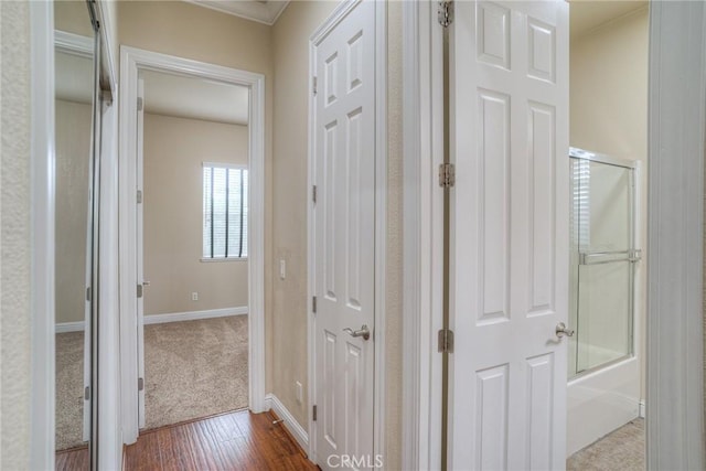 corridor with baseboards and dark wood-type flooring