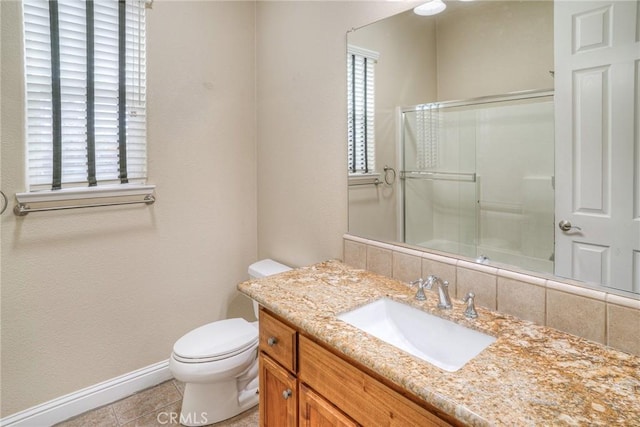 bathroom with tile patterned flooring, a shower with door, vanity, and toilet