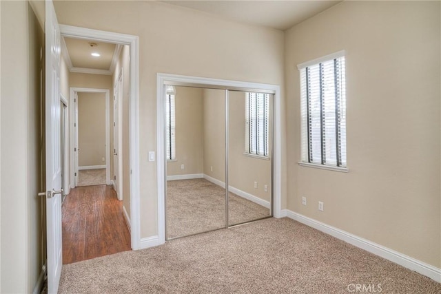 unfurnished bedroom featuring a closet, carpet flooring, and baseboards