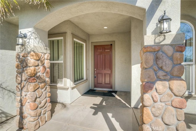 doorway to property featuring stucco siding