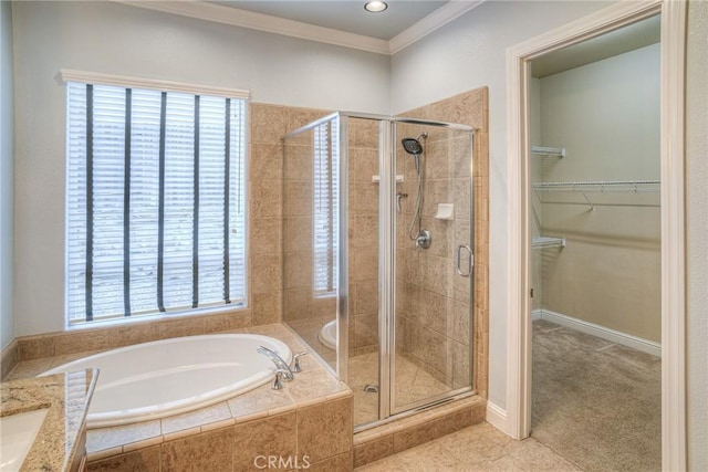 full bath featuring a stall shower, baseboards, a garden tub, a spacious closet, and crown molding