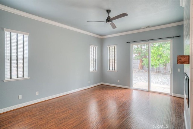 empty room with crown molding and wood finished floors