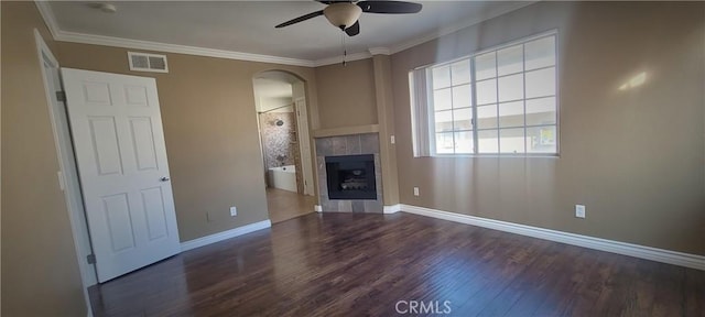 unfurnished living room featuring visible vents, a ceiling fan, wood finished floors, arched walkways, and a tile fireplace