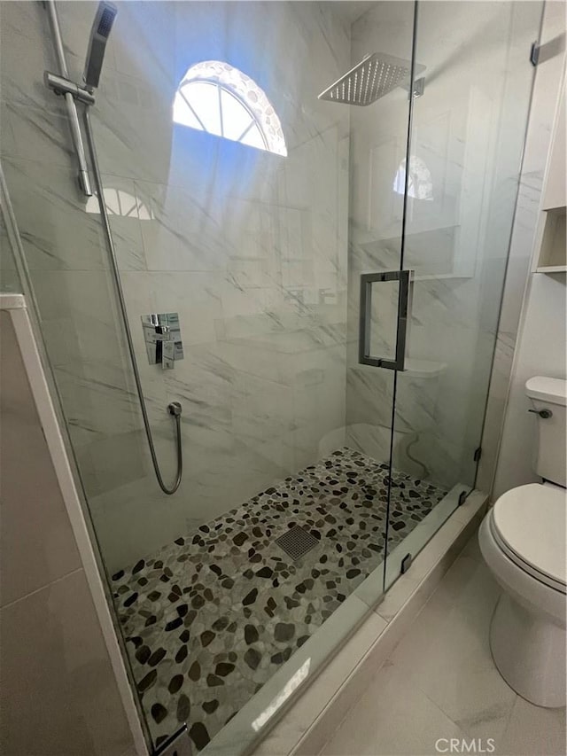 full bathroom with toilet and a marble finish shower