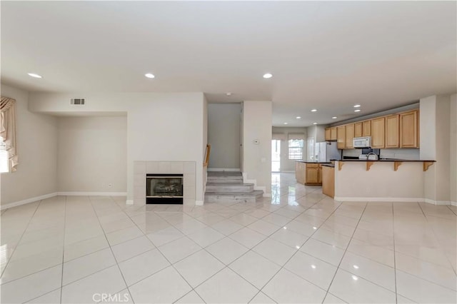 unfurnished living room featuring light tile patterned floors, baseboards, visible vents, and recessed lighting