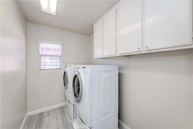 washroom featuring cabinet space, baseboards, light wood finished floors, and independent washer and dryer