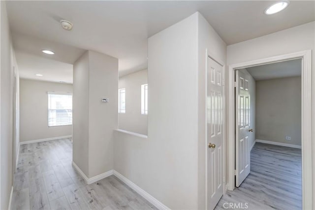 corridor with recessed lighting, light wood-style flooring, and baseboards