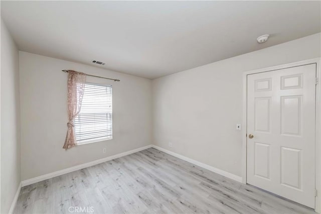 unfurnished room with baseboards, visible vents, and light wood-style floors