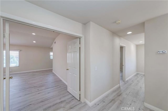 corridor featuring light wood-style floors, baseboards, and recessed lighting