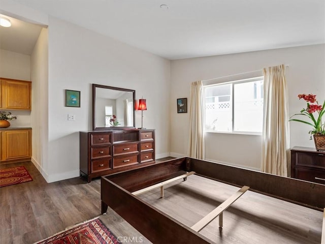 bedroom featuring baseboards and dark wood finished floors