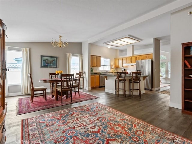 dining room featuring a notable chandelier, baseboards, vaulted ceiling, and dark wood-type flooring