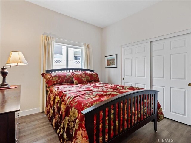 bedroom featuring a closet, baseboards, and wood finished floors