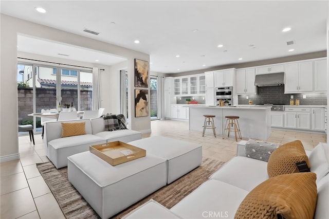 living room with recessed lighting, visible vents, and plenty of natural light