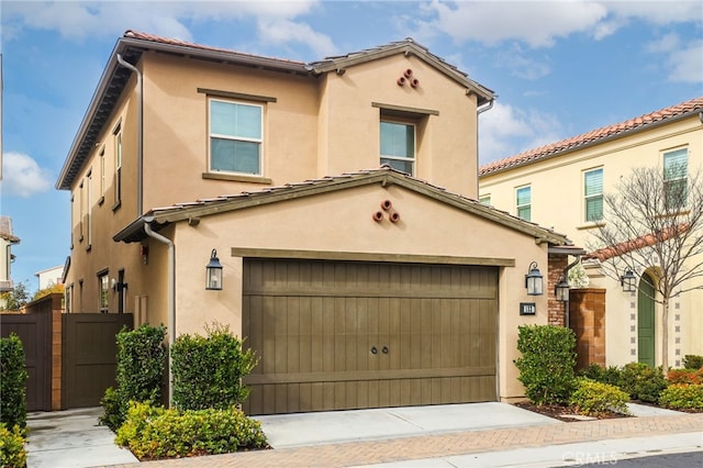 mediterranean / spanish-style house featuring driveway, an attached garage, and stucco siding