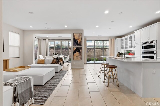 living room with light tile patterned floors and recessed lighting