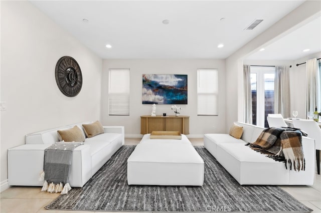 tiled living area with baseboards, visible vents, and recessed lighting