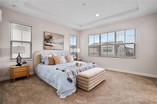 carpeted bedroom featuring recessed lighting, a raised ceiling, and baseboards