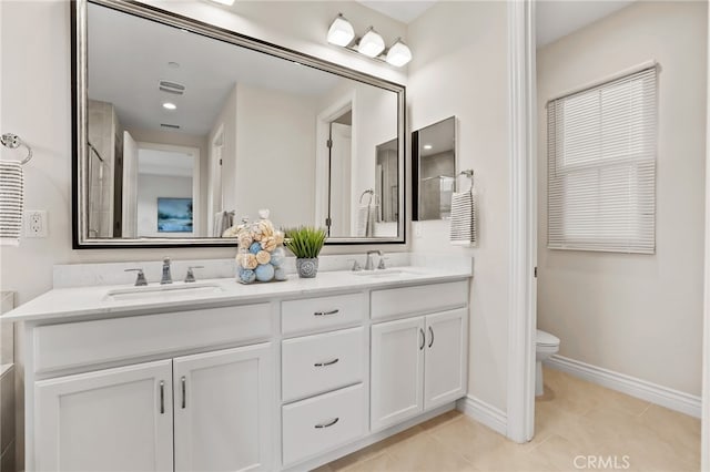 bathroom featuring toilet, double vanity, and a sink