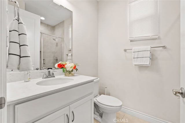 full bath with a stall shower, vanity, toilet, and baseboards