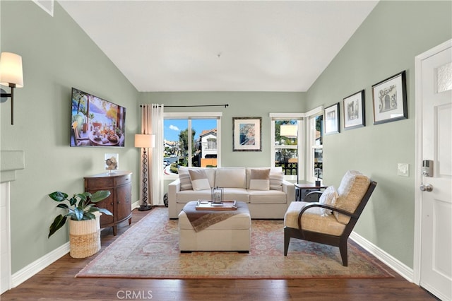 living area with lofted ceiling, wood finished floors, and baseboards