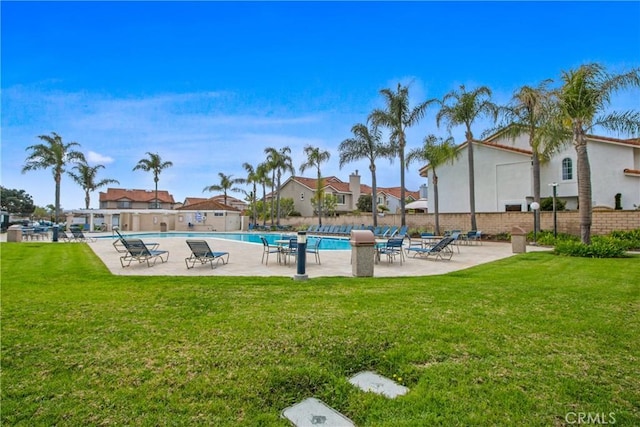 pool featuring a patio area, fence, and a lawn