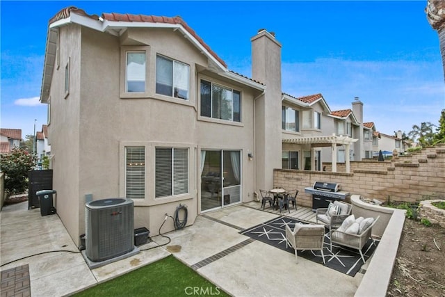 back of house with a patio, cooling unit, a pergola, a chimney, and stucco siding