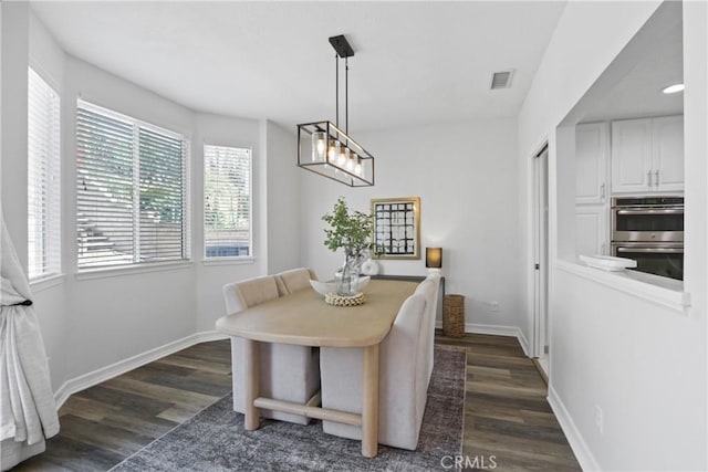 dining area featuring dark wood-type flooring, visible vents, and baseboards