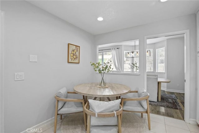 dining space featuring light tile patterned floors, breakfast area, and baseboards