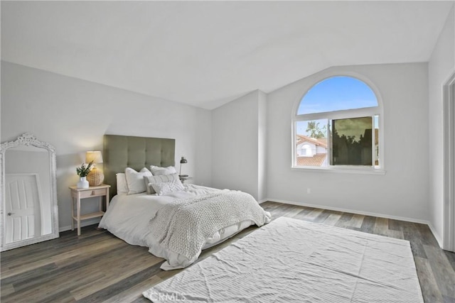 bedroom with lofted ceiling, baseboards, and wood finished floors