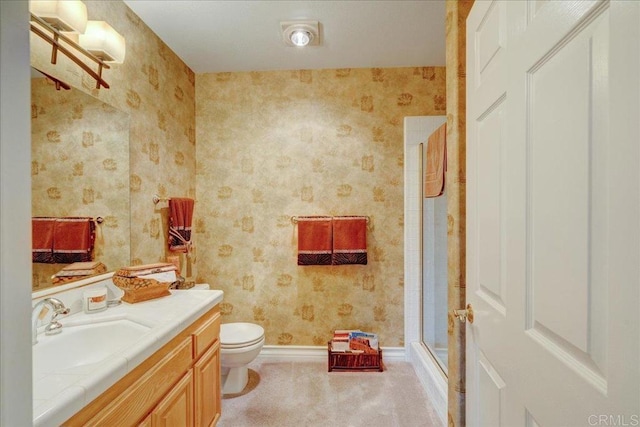 full bath with toilet, vanity, a shower with shower door, and wallpapered walls