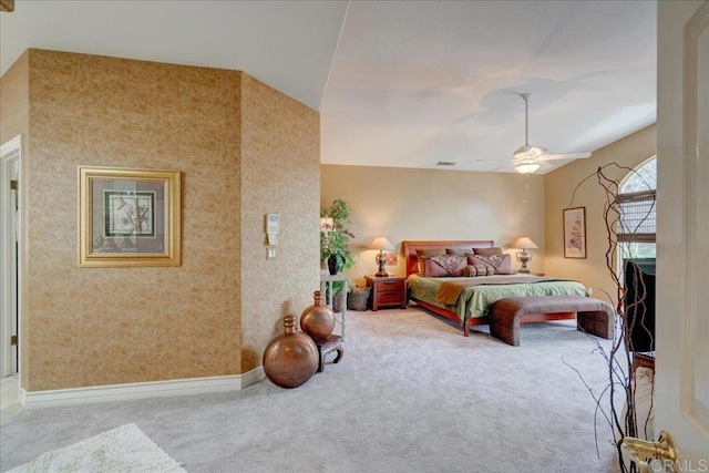 carpeted bedroom with ceiling fan and baseboards