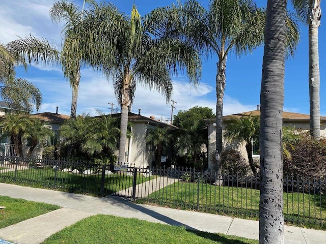 view of front of property with a fenced front yard, a front yard, and stucco siding