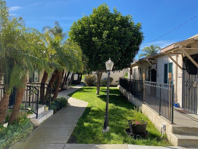 view of property's community featuring a yard and fence