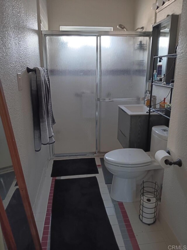 4169 Central Ave, San Diego, CA 92105 - bathroom featuring toilet, a stall shower, tile patterned floors, plenty of natural light, and a textured wall