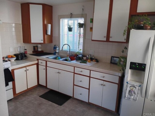 4169 Central Ave, San Diego, CA 92105 - kitchen with refrigerator with ice dispenser, a sink, backsplash, white cabinetry, and white stove