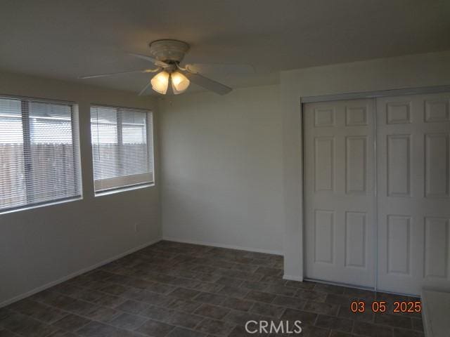 unfurnished bedroom featuring a closet, a ceiling fan, and baseboards