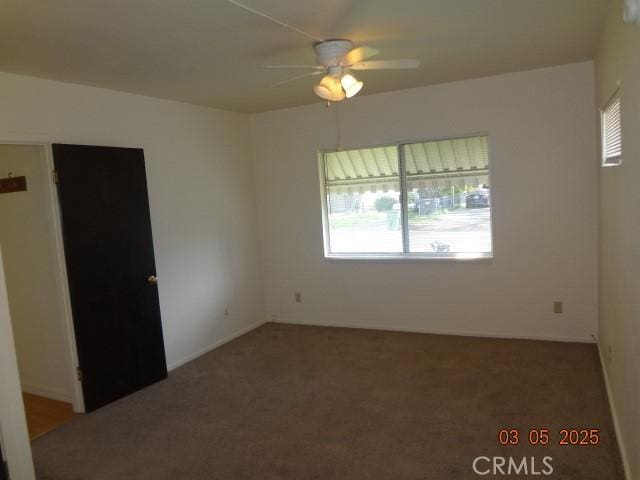 spare room with carpet and a ceiling fan