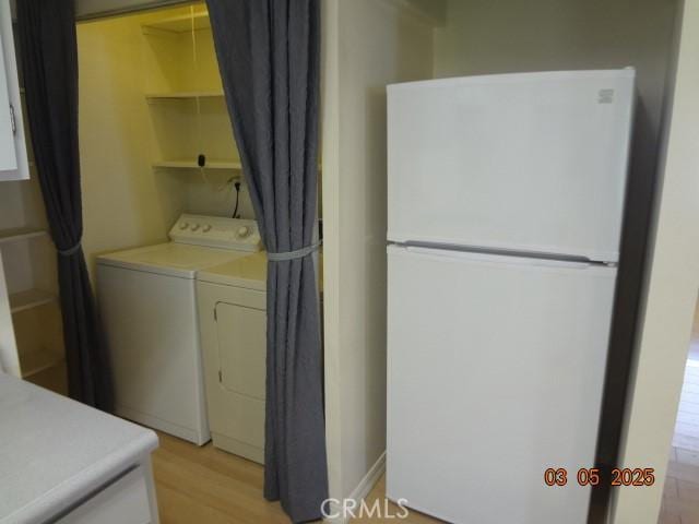 laundry room featuring laundry area, light wood-style floors, and washer and dryer