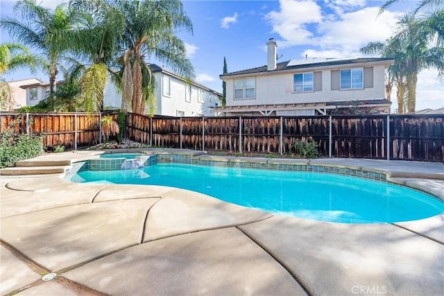 view of swimming pool featuring a patio, a pool with connected hot tub, and a fenced backyard