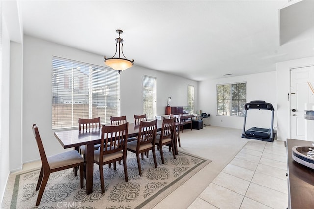 dining space with light tile patterned floors and light colored carpet