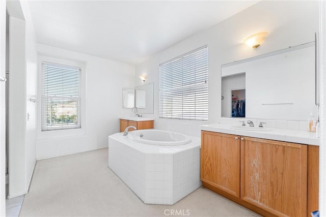 bathroom with a sink, a garden tub, and two vanities