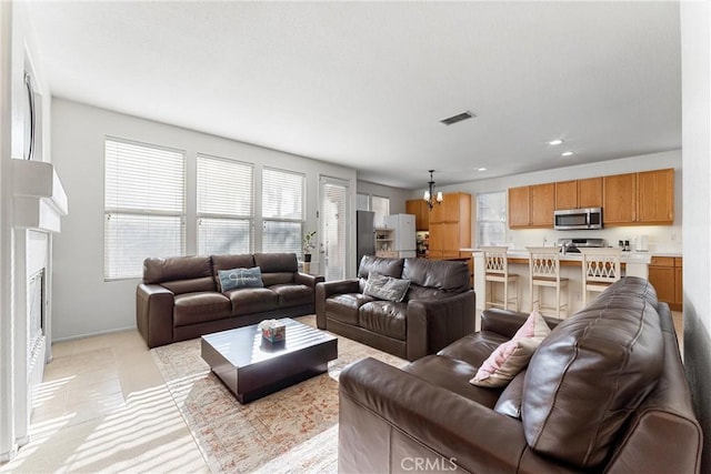 living room with visible vents, recessed lighting, a fireplace, and baseboards